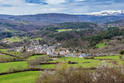 Scenic view of townscape by mountains against sky