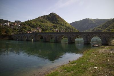 Bridge over river against mountain
