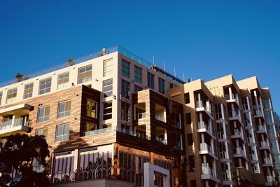 Low angle view of buildings against clear blue sky