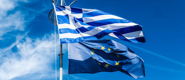 Low angle view of flag against blue sky