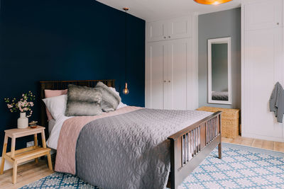 Bed by mirror and cabinet in bedroom