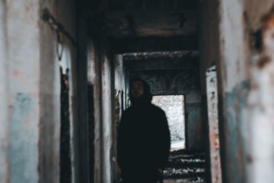 Rear view of man standing in abandoned building