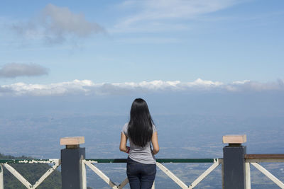Rear view of woman with long black hair looking at mountains