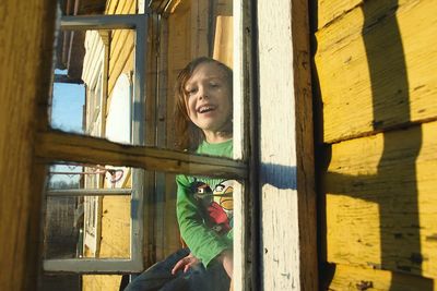 Portrait of girl holding window