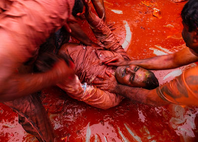 High angle view of friends playing holi in city