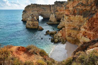 Rock formations by sea against sky