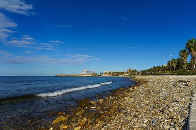 Scenic view of beach against blue sky