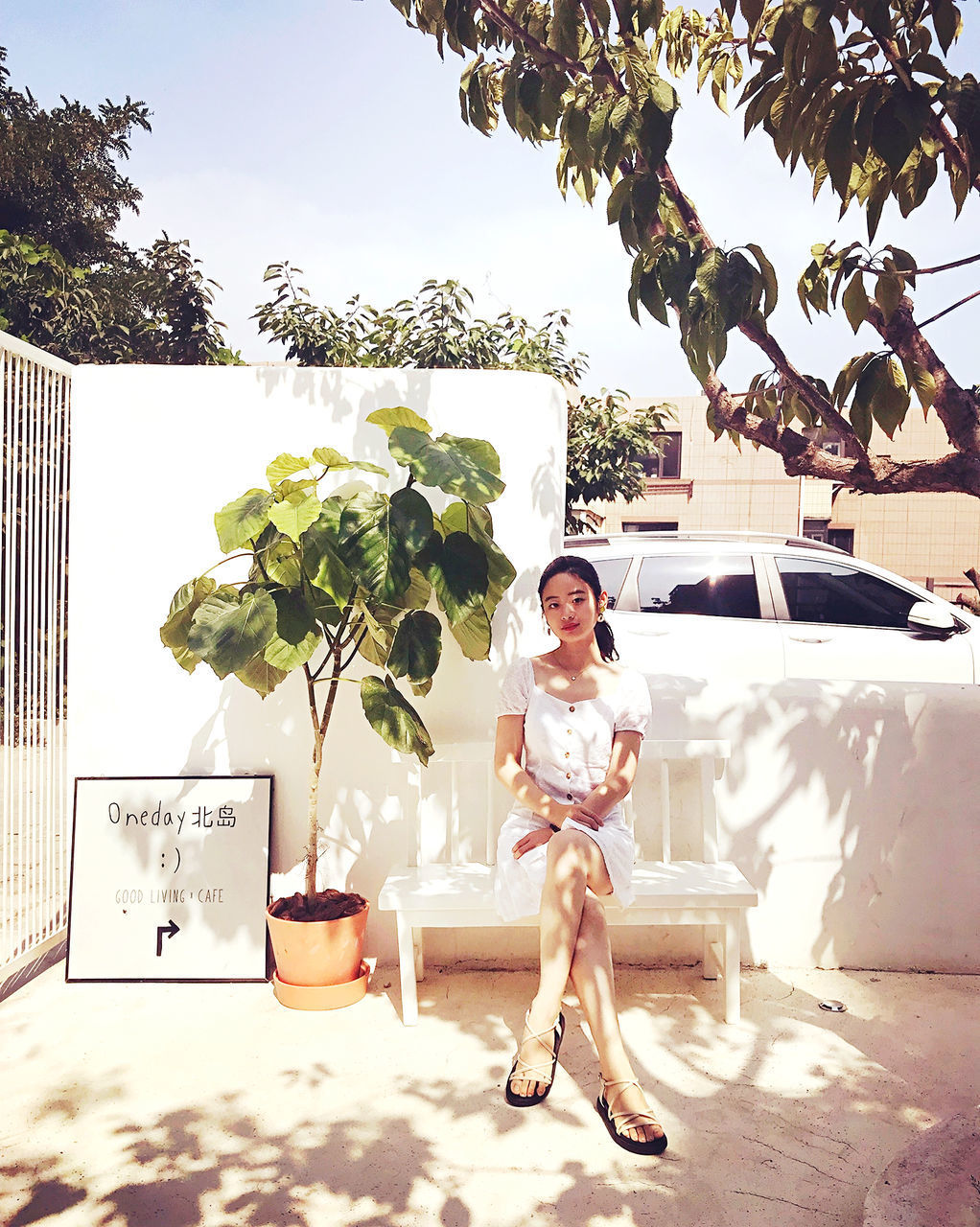 PORTRAIT OF SMILING WOMAN STANDING AGAINST TREES