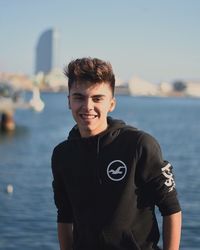 Portrait of young man standing against sea