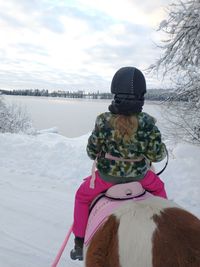 Rear view of woman on snow covered land