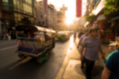 Rear view of people walking on road in city