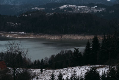 Scenic view of lake by snowcapped mountains during winter