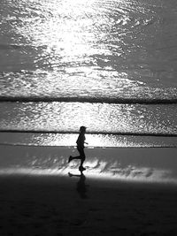 Rear view of a man walking on beach