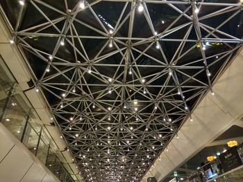 Illuminated railroad station against sky at night