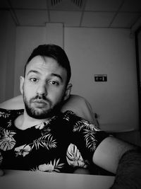 Portrait of young man relaxing on bed at home