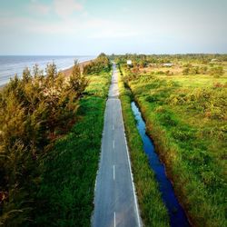 Empty road amidst land against sky