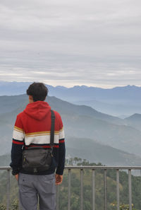 Back view of a man looking to mountains while standing outdoors 