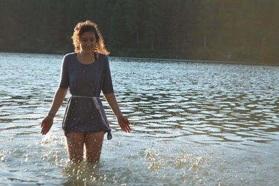 Portrait of young woman standing in sea