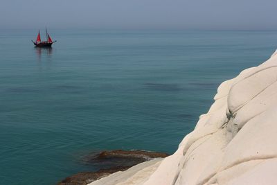 Sailboat in sea against sky