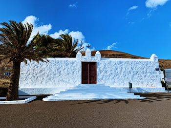 Built structure on beach by sea against sky