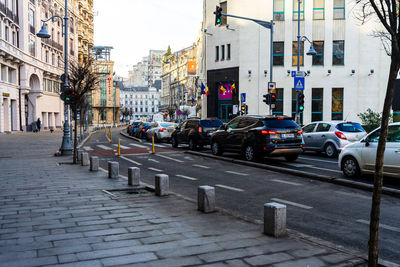 Traffic on road by buildings in city