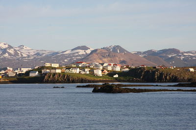 Scenic view of lake by mountains against clear sky