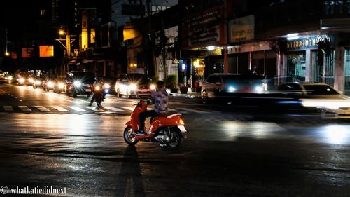 People riding motorcycle on street at night