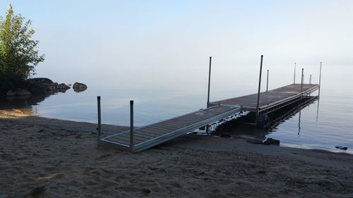 Wooden posts on beach against sky