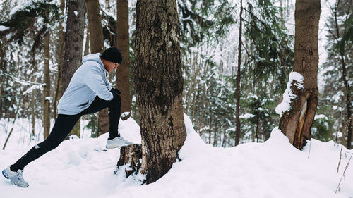 Man exercising on snow covered field during winter