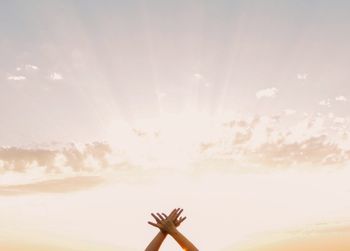 Low angle view of person hand against sky