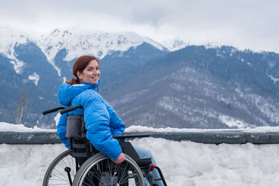 Side view of man standing on snowcapped mountain