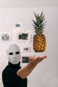 Mask man levitating pineapple