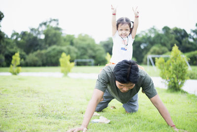 Portrait of young woman exercising on field