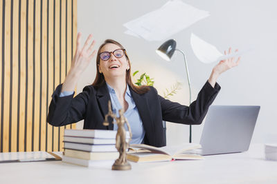 Young woman using laptop while sitting on table