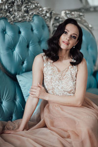 Beautiful young woman sitting with arms raised