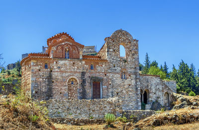 Low angle view of old building against clear blue sky