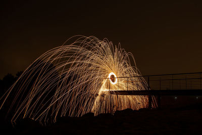 Illuminated ferris wheel against sky at night