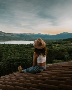 Woman on a roof looking at the sunset