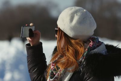 Rear view of woman photographing