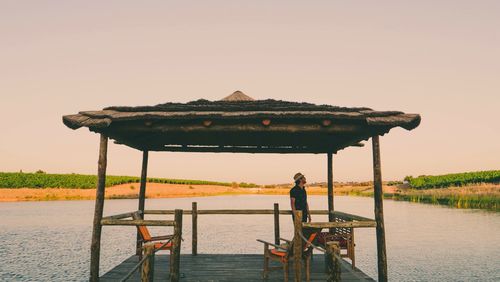 Man standing by lake against clear sky