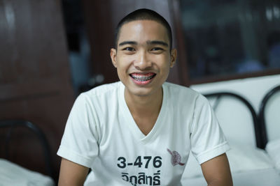 Portrait of smiling young man sitting on bed