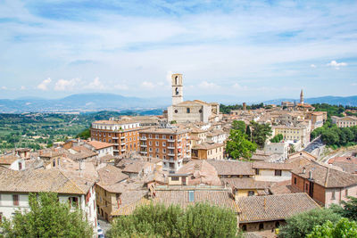 High angle view of buildings in town against cloudy sky