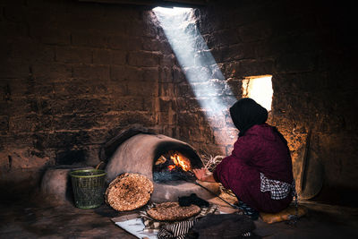 Midsection of woman preparing food against wall