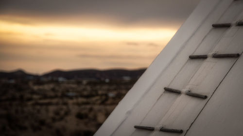 Close-up of airplane against sky during sunset