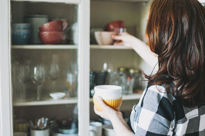 Rear view of woman having food at home