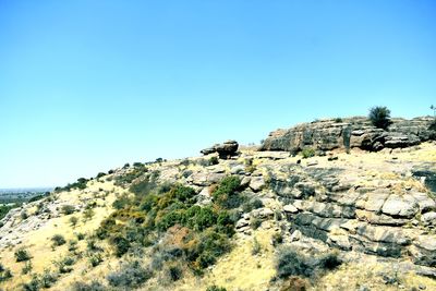 Rock formations against clear blue sky