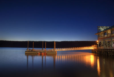 Illuminated pier and floating platform in hudson river at dusk