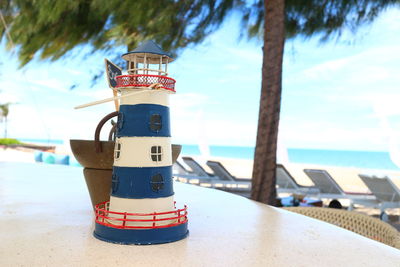 Close-up of lighthouse by sea against sky