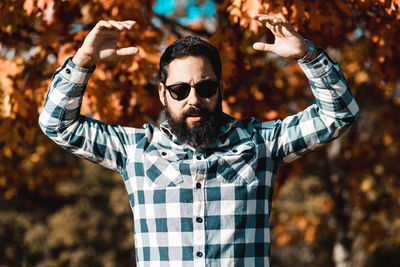 Man wearing sunglasses while standing against trees