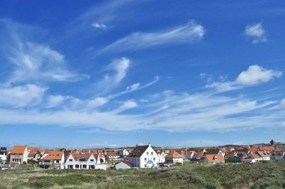 Houses in town against blue sky